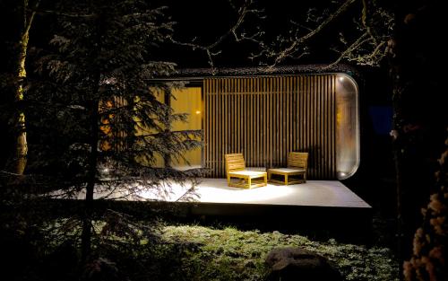 two chairs sitting on a patio at night at Chalets & Apartments - Base Camp Medvědín in Špindlerův Mlýn