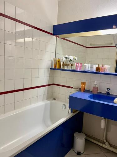 La salle de bains est pourvue d'une baignoire et d'un lavabo bleu. dans l'établissement Verrerie beach, à Cannes