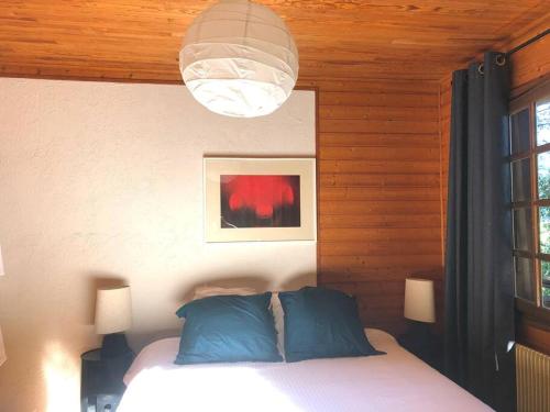 a bedroom with a bed with blue pillows and a light at Chalet de charme - vue panoramique in Combloux