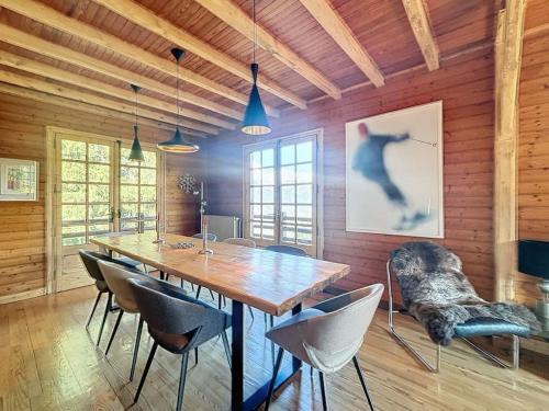 une salle à manger avec une grande table et des chaises en bois dans l'établissement Chalet de charme - vue panoramique, à Combloux