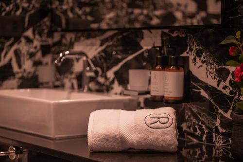 a bathroom with a sink and a towel at Royale Sainte Hélène Boutique Hotel in Birkirkara