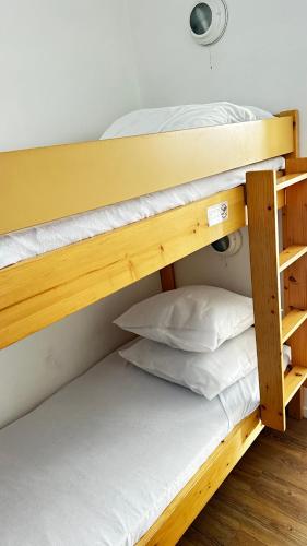 Ce dortoir comprend 2 lits superposés et des oreillers blancs. dans l'établissement Appartement et Balcon Entier 4 personnes climatisé plage a 100 m, à Saint-Raphaël