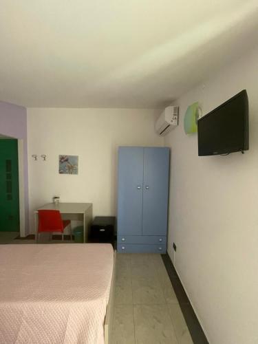 a bedroom with a blue cabinet and a tv on the wall at B&B Le Terrazze in Crotone