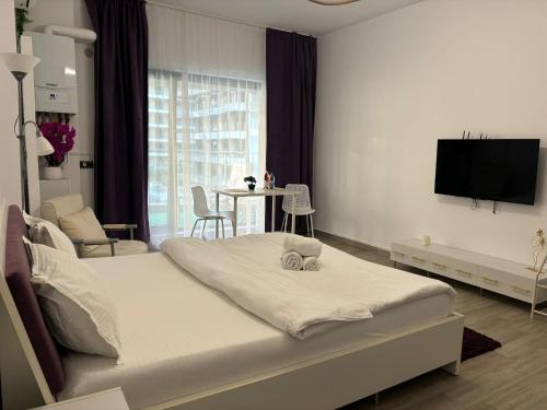 a bedroom with a bed and a tv on a wall at Ametist in Mamaia