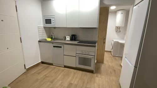 a small kitchen with white cabinets and a wooden floor at Rockside Residences Suites La Línea N3 in La Línea de la Concepción