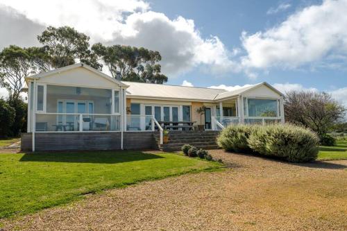 a large white house with a grass yard at Bayview Farm Bashams in Port Elliot
