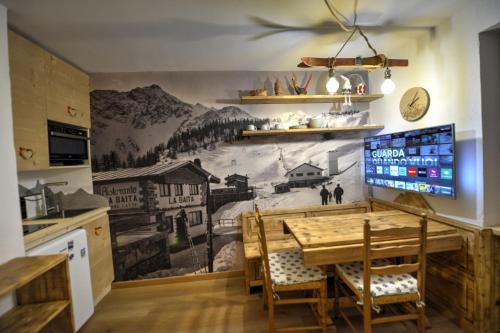a kitchen with a table and a mural on the wall at Memoire du Mont Blanc in Morgex