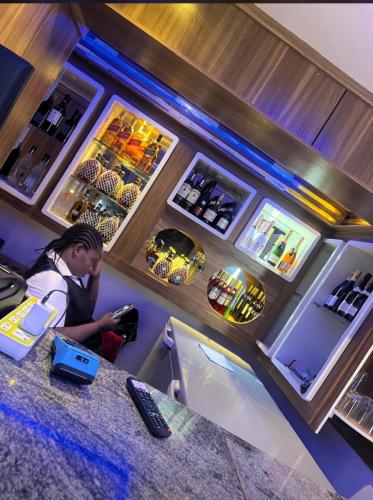 a man sitting at a counter in a bar at Keneuro hotel & suites in Lagos