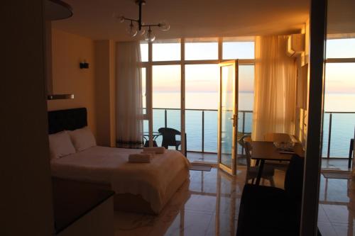 a bedroom with a bed and a view of the ocean at SEA in Batumi