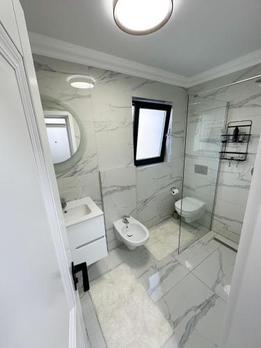 a bathroom with a sink toilet and a shower at Porcelain Apartment in Rădăuţi
