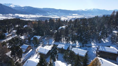 un village recouvert de neige avec des arbres et des montagnes dans l'établissement Chalets Collection Cachemire - Les Chalets Secrets, à Bolquère-Pyrénées 2000