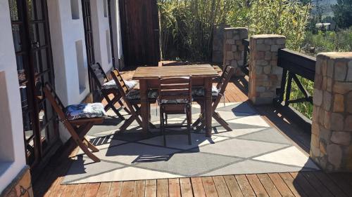 a wooden table and chairs on a patio at Mountain Pastures Game Lodge in Uniondale