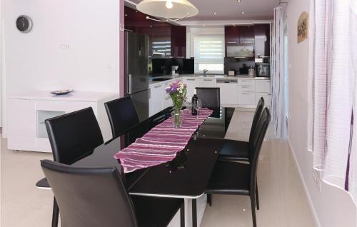 a black dining room table with black chairs and a kitchen at Amazing Home In Kastel Stafilic in Plano