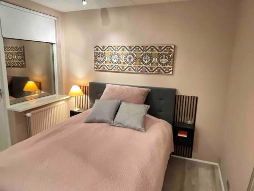 a bedroom with a pink bed with two pillows at Bright house for 6 people, with hut tub in garden in Reykjavík