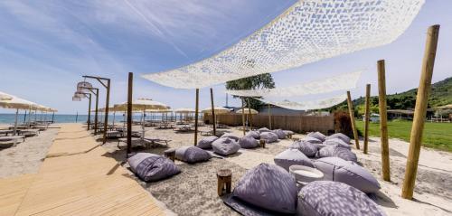 a beach with purple umbrellas and chairs on the sand at Effect Algara Beach Resort - Ultra All Inclusive and Free Parking in Kranevo