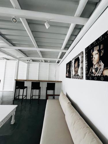 a room with a couch and posters on the wall at Summerdays Studios in Coteau Raffin