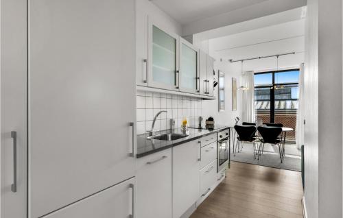 a white kitchen with a sink and a counter at Fanø Bad, Lejl 57 in Fanø