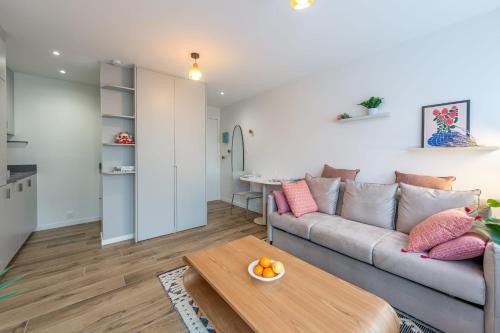 アヌシーにあるLac Pershing - Appartement confortable à deux pas du lacのソファとテーブルのあるリビングルーム