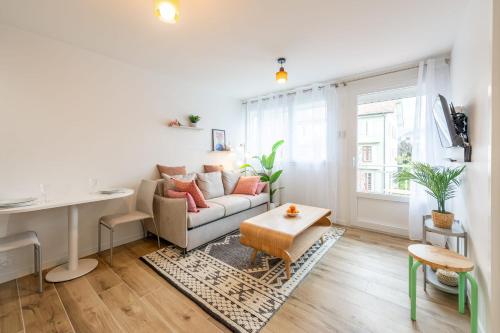 アヌシーにあるLac Pershing - Appartement confortable à deux pas du lacのソファとテーブルのあるリビングルーム