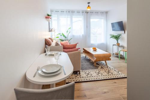 un salon avec une table blanche et un canapé dans l'établissement Lac Pershing - Appartement confortable à deux pas du lac, à Annecy