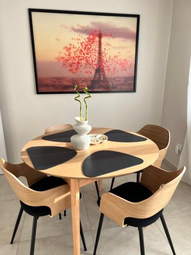 a dining room table and chairs with a picture of the eiffel tower at Villa Ana - Charming Appartments in Belgrade