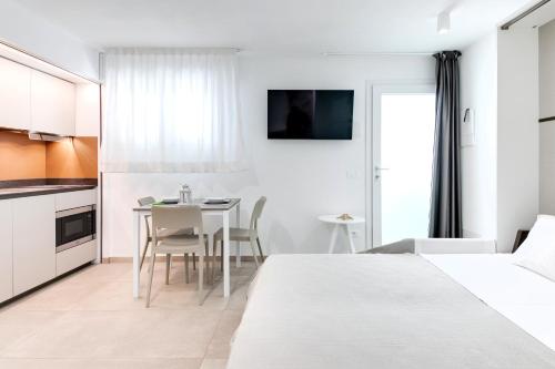 a bedroom with two beds and a table with chairs at Residence Diffuso Arcobaleno in Gabicce Mare