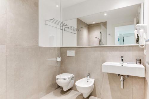 a bathroom with a toilet and a sink and a mirror at Residence Diffuso Arcobaleno in Gabicce Mare