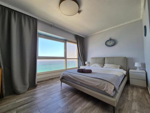 バト・ヤムにあるUrban Beach Apartmentsの海の見えるベッドのある寝室