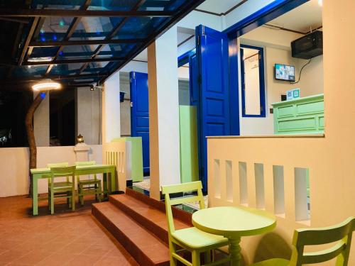 a restaurant with tables and chairs and a blue door at Vip KINGSON GUEST HOUSE in Luang Prabang