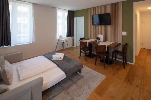 a hotel room with a bed and a dining room at BERG & BERG APARTMENTS - Spiez Self-Check-in in Spiez
