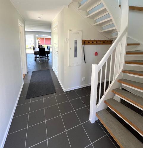 a hallway with stairs leading to a dining room at Saxnäs Ferieboende Valkyria in Färjestaden