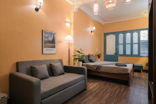 a living room with a couch and a bed at Bridgo Home, by Hoan Kiem lake side - by Antique in Hanoi