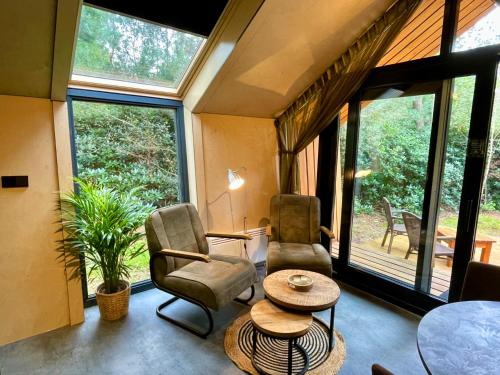 a living room with two chairs and a table at Diamond Suite in the woods in Holten