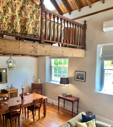 a living room with a wooden table and a staircase at Clare Valley Heritage Retreat in Clare