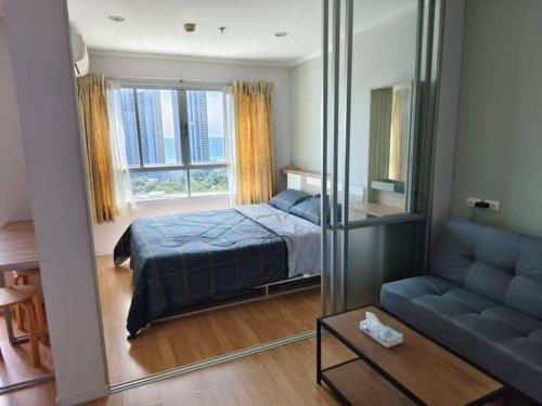a bedroom with a bed and a couch and a mirror at LumpiniC17 in North Pattaya