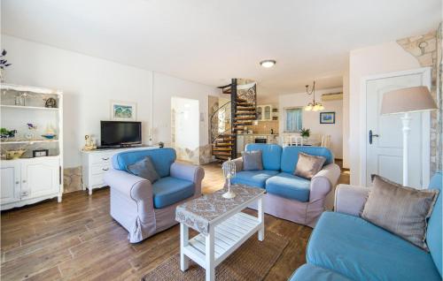 a living room with blue couches and a tv at Holiday Home Kremena 72 With Outdoor Swimmingpool in Klek