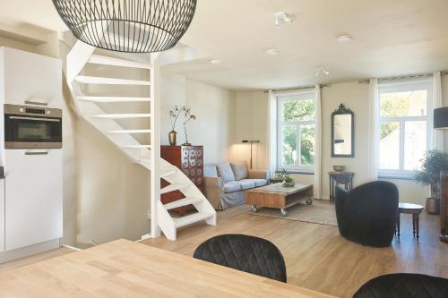 a living room with a spiral staircase in a house at Apartment Bolwerkzicht in Middelburg