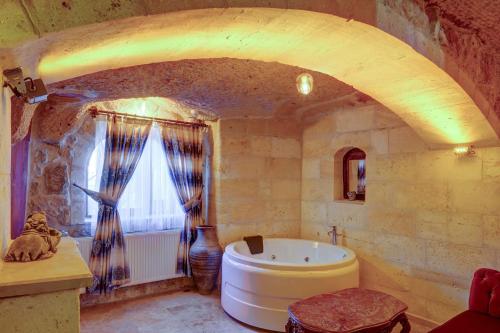 a bathroom with a large tub and a window at Mizan Cave Cappadocia in Nevsehir