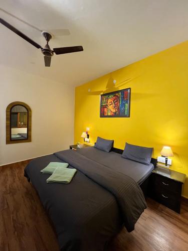 a bedroom with a large bed with a yellow wall at Himtrek Stays,Mcleodganj in McLeod Ganj