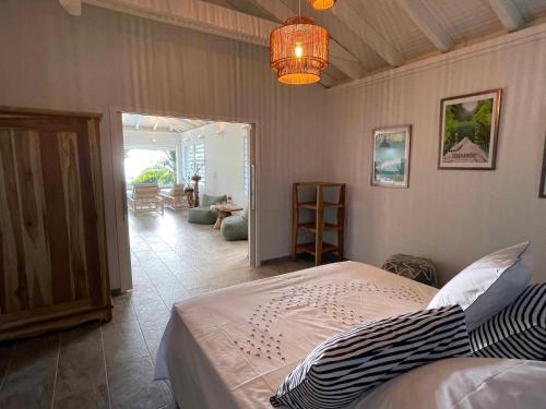 a bedroom with a bed and a living room at villa COLIBRI in Le Diamant