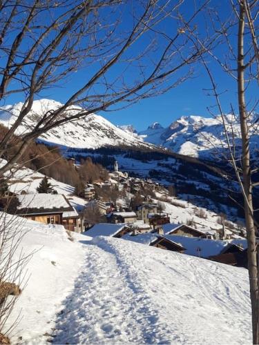 a snow covered mountain with a town in the distance at Accogliente casa in montagna in Champoluc