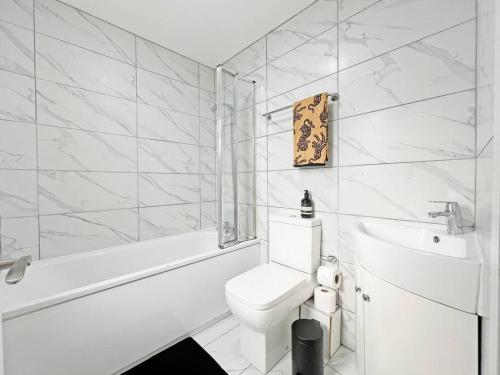 a white bathroom with a toilet and a bath tub at Luxury Central Windsor 5 Bed Home, Parking, Private Garden - Windsor Castle View, Legoland, Ascot, Heathrow Airport in Windsor