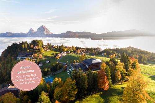 an aerial view of a resort on a hill with a mountain at Wellness Hotel Stoos in Stoos