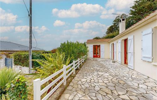 a stone walkway leading to a house with red doors at Gorgeous Home In Meschers-Sur-Gironde in Meschers-sur-Gironde