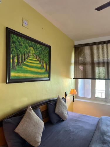 a bedroom with a large painting on the wall at Himtrek Stays,Mcleodganj in McLeod Ganj