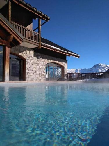 une grande piscine d'eau devant un bâtiment dans l'établissement Studio 4 personnes pied des pistes avec piscine, à Villarembert