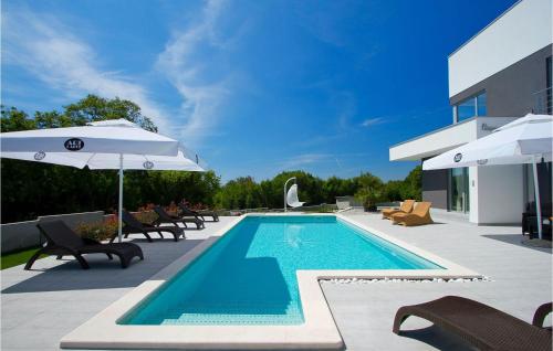 een zwembad met stoelen en parasols naast een gebouw bij Villa Windrose in Pula