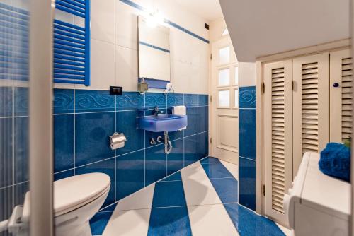 Un baño azul y blanco con inodoro y lavabo. en Beppo Sea View, en Rovinj