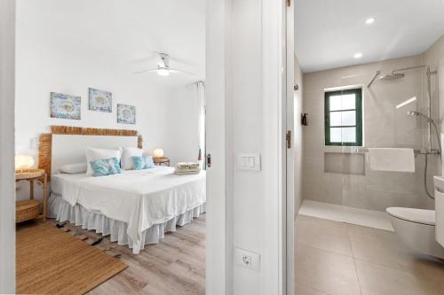 a bedroom with a bed and a shower and a bathroom at Casa Yaiza in Puerto Calero