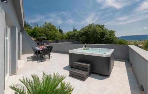 a hot tub on top of a balcony with a table at Gorgeous Home In Donji Vinjani in Topići